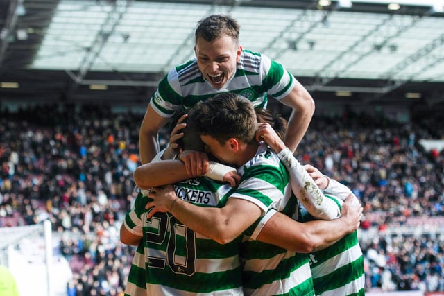 Alistair Johnston jumps on top of his team-mates as Celtic celebrating scoring three goals against Hearts for the second time in four days.