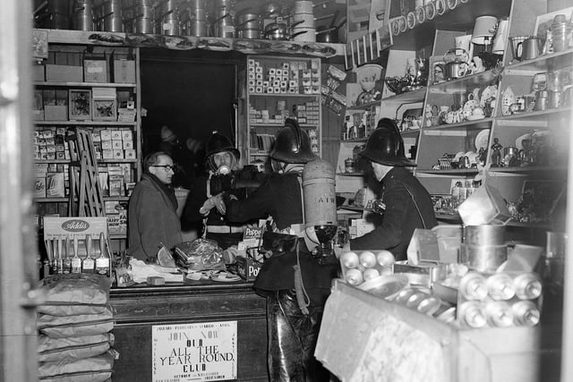 This picture was taken after a fire in an ironmonger's shop on Dalry Road in December 1961. Owner Mr A Brown watches firemen deal with the situation.