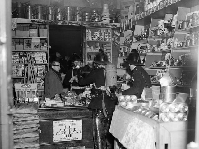 This picture was taken after a fire in an ironmonger's shop on Dalry Road in December 1961. Owner Mr A Brown watches firemen deal with the situation.