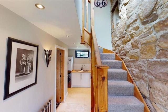 There is a feature exposed stone wall and oak floor covering.