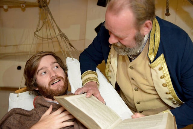 National Museum of the Royal Navy staff member Stuart Burke reads a scary night time story to Jonathan Clough in this reminder of a 2017 Halloween event.