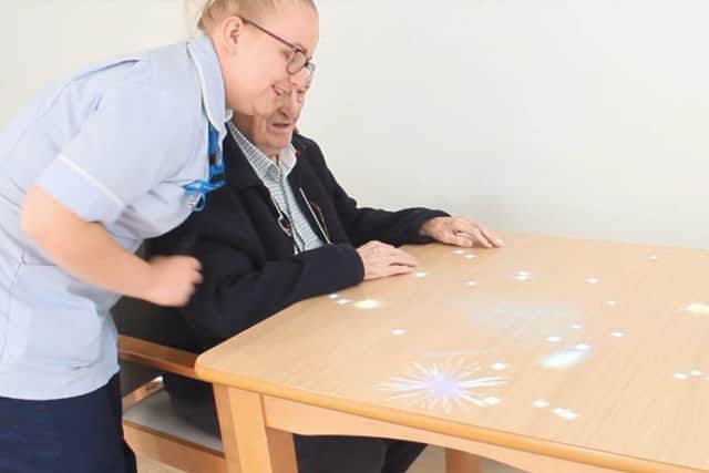 A resident and staff member using the magic table.