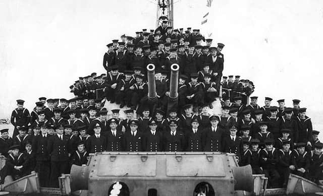 Crew member of HMS Lapwing. Here we see the officers and men of the ship gathered around A & B turrets.  