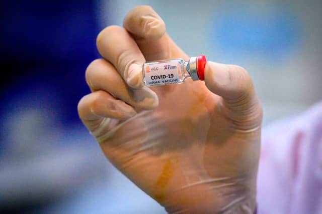 Laboratory technician holding a dose of a COVID-19 novel coronavirus vaccine candidate (Photo by MLADEN ANTONOV/AFP via Getty Images)