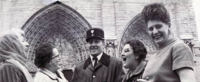 The Star Women's Circle trip to Paris, April 15, 1970. Members of the party are seen making friends with a gendarme while visiting Notre Dame Cathedral.