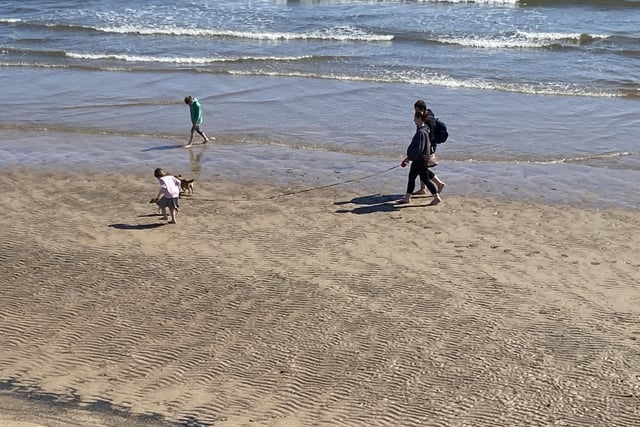 This family enjoys a beach stroll and a paddle. Picture by FRANK REID