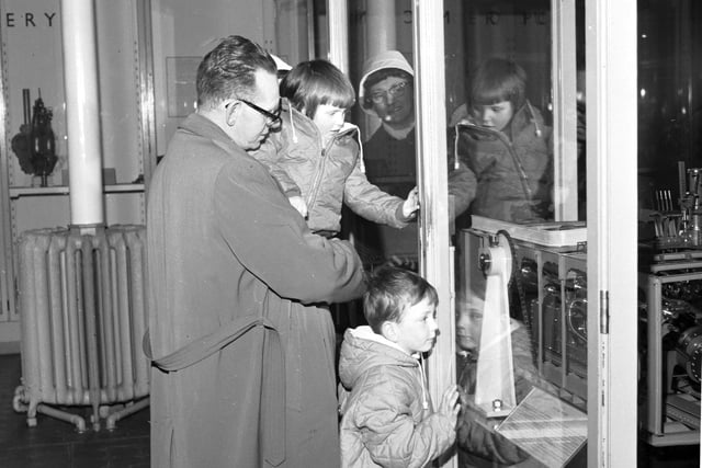 A family looks at one of the interactive displays in the Royal Museum of Scotland, with one of the children pushing the button, in April 1966.