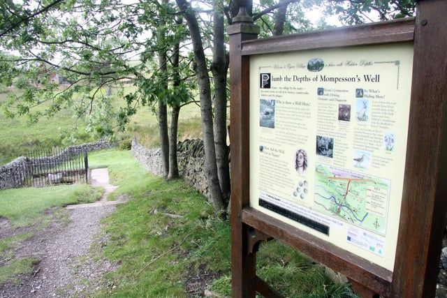 An information board telling visitors about Mompesson's Well which was used along with the boundary stone for the villagers of Eyam to exchange money for food with other villages, picture taken in 2011