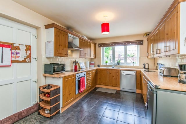 The main kitchen area is of a good size and boasts all the amenities you need, including a range of wood-effect wall and base units, integrated electric oven, stainless-steel sink and ceramic tiled floor.