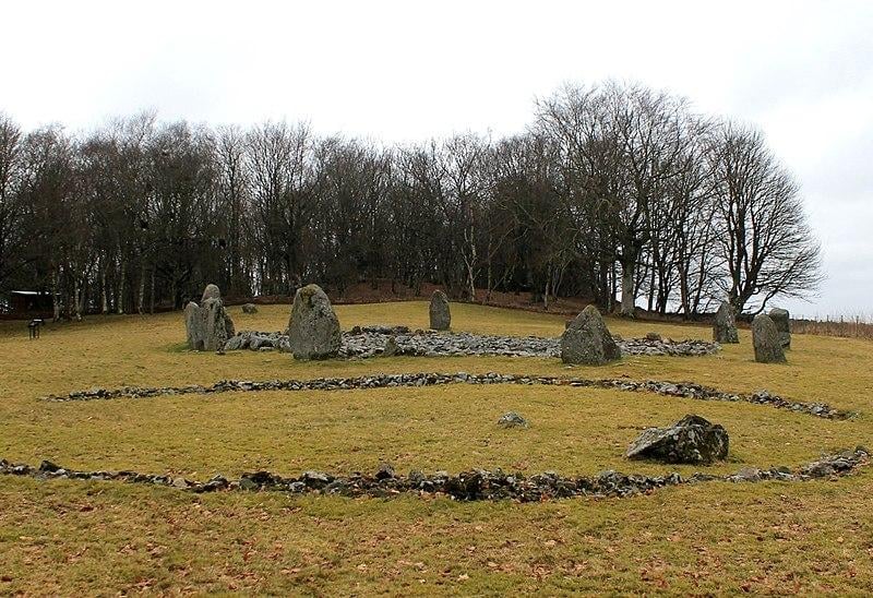 The site is 500m from top of village. Impressive and spooky circle of 11 stones and one recumbent from 4,000/5,000BC. Unusual second circle adjacent encloses a cremation cemetery from 1,500 bc. Remains of 32 people were found here. Obviously, an important place. God knows what they were up to.