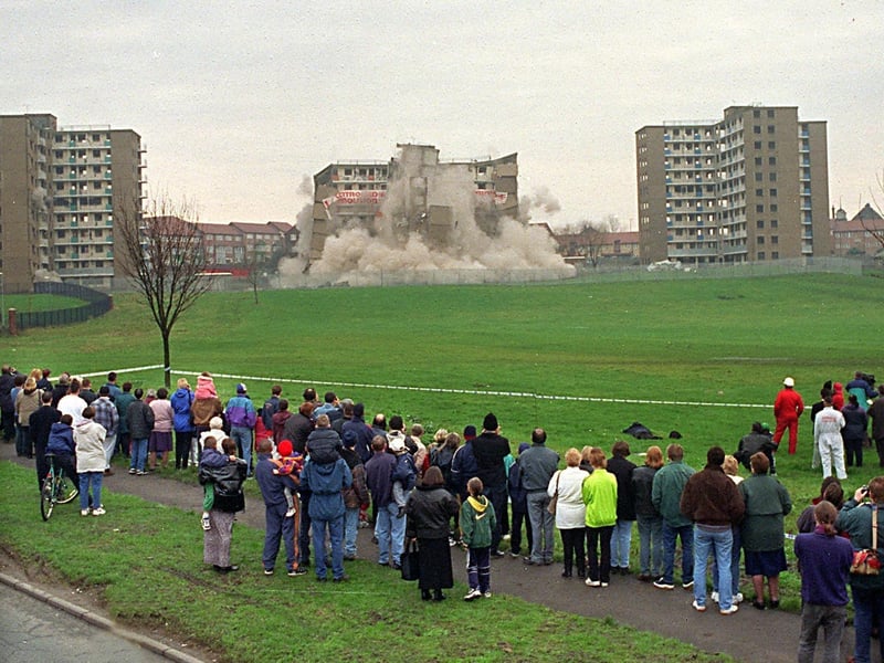 A controlled explosion brings down one of the three 10-storey tower blocks at Rigton Drive, Leeds, as spectators look on, in December 1997