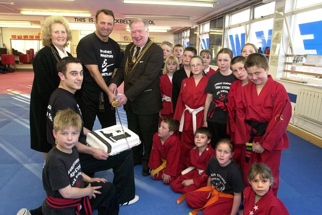 Kim Stones (stood, second left), of the Kim Stones Academy, celebrated 30 years involvement with martial arts in 2003. Our picture shows him cutting a birthday cake with sword, helped by the Civic Mayor of Doncaster, Councillor John Quinn. Looking on are the Mayoress, Mrs Ella Quinn, and members of the Academy.