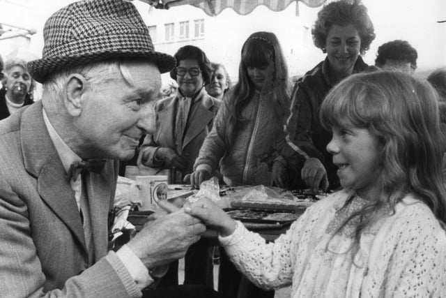 Jewellery seller Eddie Davison meets a young customer in this market scene from August 1982.