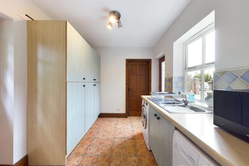 Utility Room with exterior door to the front elevation, a range of fitted units with complementary work-surface, inset sink with mixer tap, plumbing for automatic washing machine,  timber framed part glazed stable door opening onto the rear courtyard.