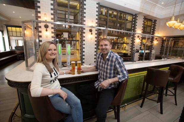 Ardnamurchan owners Neil and Julia Douglas are pictured enjoying a pint in front of a protective perspex screen, which runs the length of the bar to protect staff and customers.