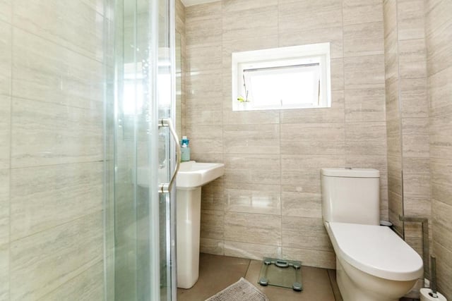 The bathroom continues the modern theme with a walk-in shower and contemporary decor.