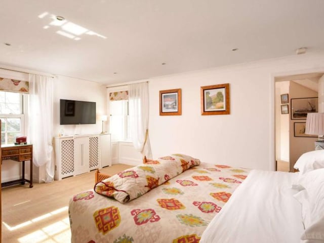 The master bedroom enjoys an en suite shower room and bathroom, with windows allowing loads of natural light to flood the room