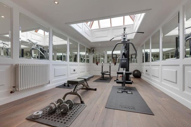 This well-proportioned at-home gym provides plenty of space for several pieces of workout equipment, and includes mirrored walls, data points and a built-in surround sound system.