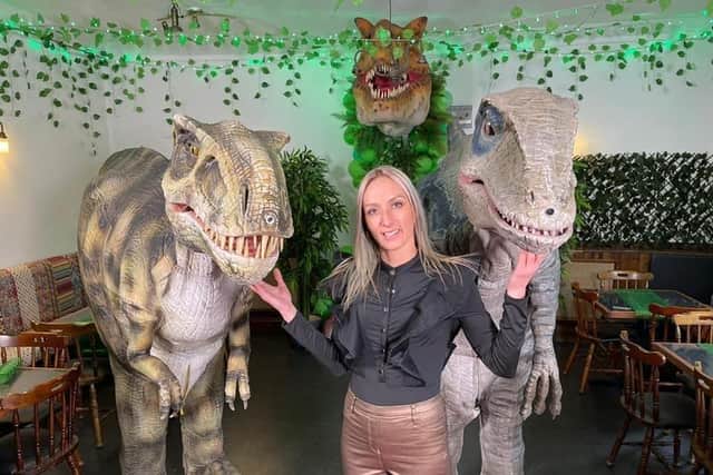 Jurassica owner Chantelle Synyer with the two animatronic dinosaurs Tricksy the T-Rex and Bluey the Velociraptor at the dinosaur-themed pub in Ecclesfield, Sheffield. The venue has now lost its licence
