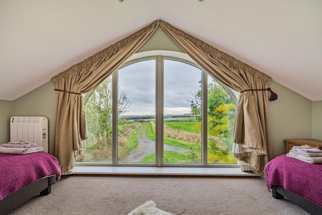 The second floor has two double bedrooms, both of which have striking full-height arched windows, affording views towards the coast to the east, and across the surrounding woodland to the west.
