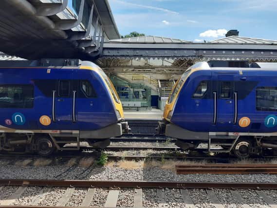 Two trains parked on the middle track going nowhere at Sheffield Midland station.