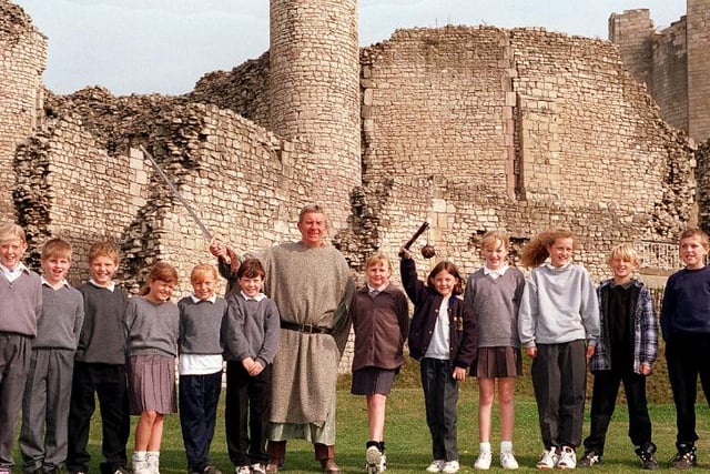 A group of school children learning all about the local history in 1996 with castle guide Dave Haywood.