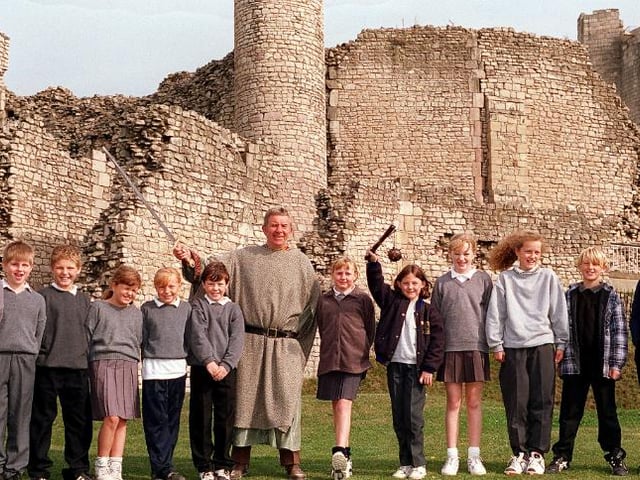 A group of school children learning all about the local history in 1996 with castle guide Dave Haywood.