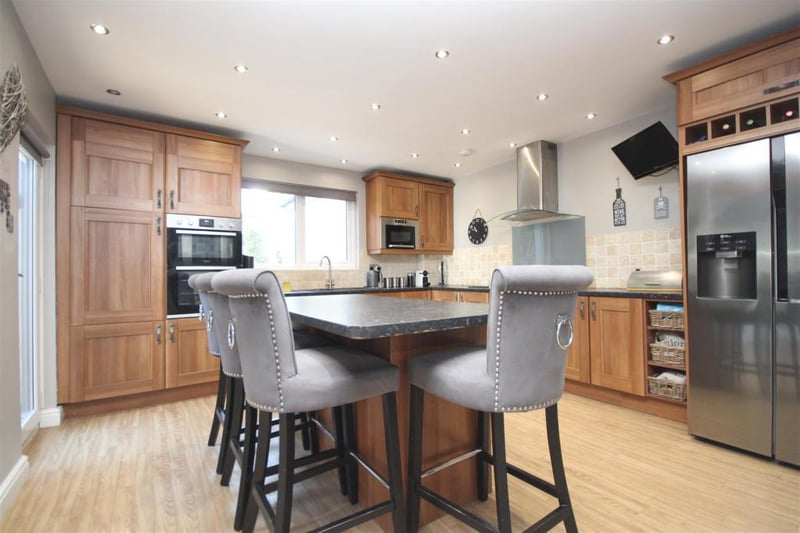 The kitchen features an integrated oven and hob, as well as a wine rack.