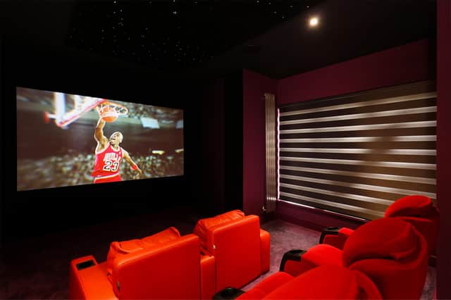 Plush red seats and recessed lights create an authentic cinema experience.