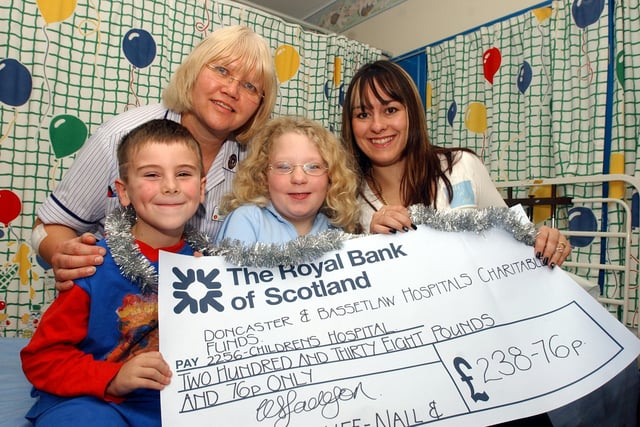 Denaby beautician Kelly Jackson, aged 26, owner of Nails and Stuff, presents a cheque for £238.76 to patients Connor Godley, aged six, and Rebecca Hood, aged eight, of Wheatley, and staff nurse Christine Vincent at Doncaster Royal Infirmary's Children's Hospital in 2004.