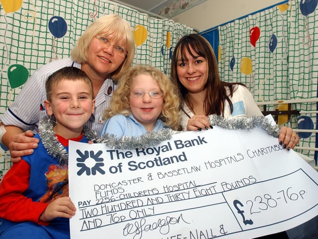 Denaby beautician Kelly Jackson, aged 26, owner of Nails and Stuff, presents a cheque for £238.76 to patients Connor Godley, aged six, and Rebecca Hood, aged eight, of Wheatley, and staff nurse Christine Vincent at Doncaster Royal Infirmary's Children's Hospital in 2004.