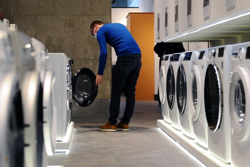 A customers inspects a washing machine in the new large electrical and fitted kitchen section of the store.