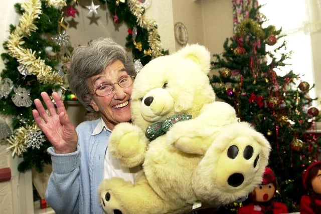 Bertha Partridge, aged 83 holding a large teddy bear at the annual Christmas Fayre held at the Woodlea Residential Home. 2003.