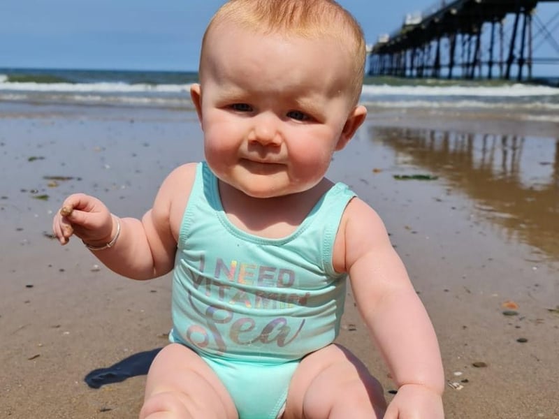 This tot has been to the beach.