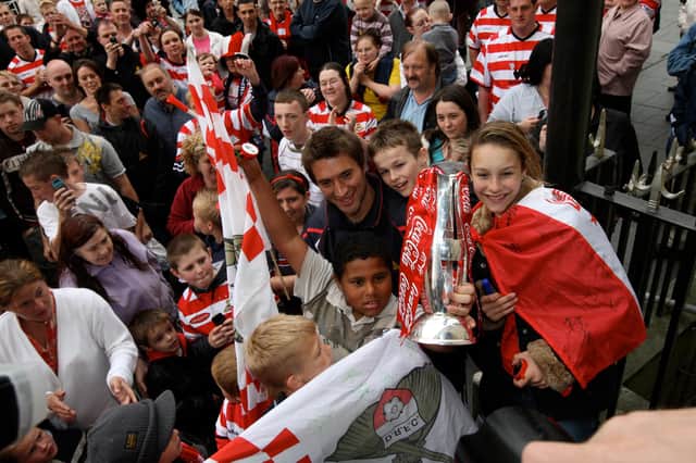 Graeme Lee poses with fans and the play-off trophy outside the Mansion House