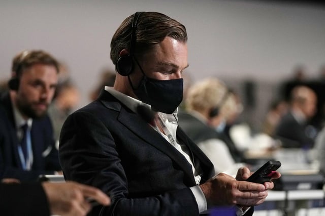 DiCaprio looked at a mobile phone as he attended a panel discussion.