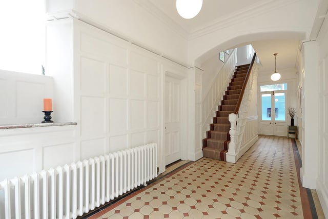 Crisp white walls, patterned tiles and an enviable column radiator are standout features in the entrance hall.