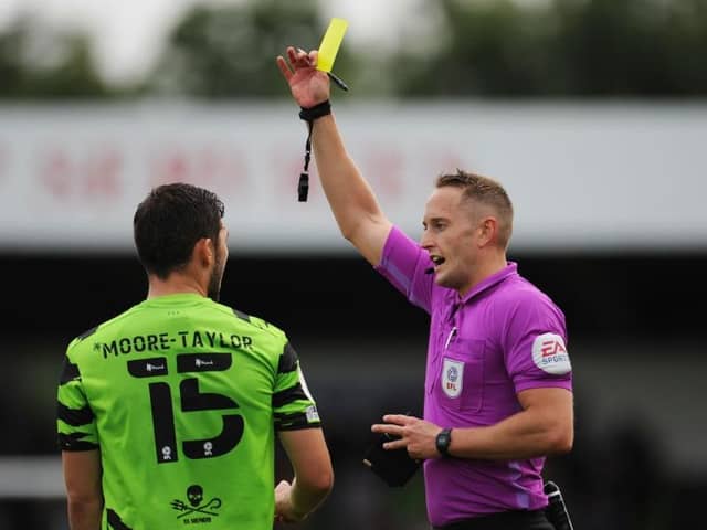 NAILSWORTH, ENGLAND - AUGUST 07: Match Referee James Bell shows a yellow card to Jordan Moore-Taylor of Forest Green Rovers during the Sky Bet League Two match between Forest Green Rovers and Sutton United at The Fully Charged New Lawn on August 07, 2021 in Nailsworth, England. (Photo by Alex Burstow/Getty Images)