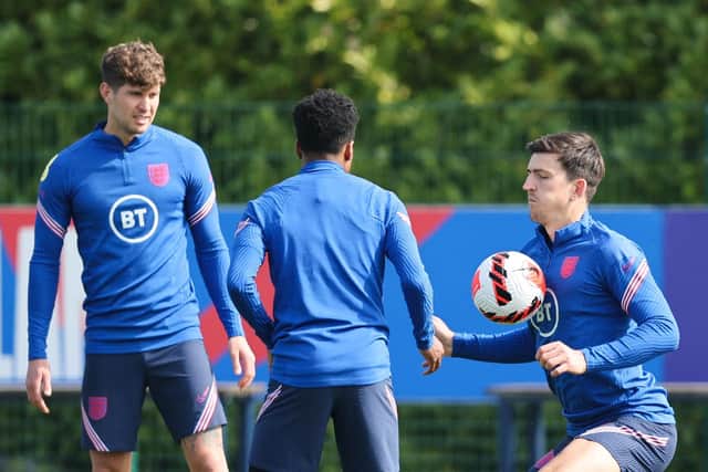 Harry Maguire (R) controls tha ball in front of John Stones (L) and Kyle Walker-Peters (C) as they take part in the training session of England's football team at the Tottenham Hotspur Football Club Training Ground (Photo by ADRIAN DENNIS/AFP via Getty Images)
