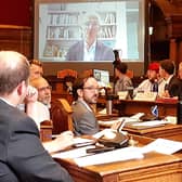 Councillors watch on screens as Sir Mark Lowcock speaks about his inquiry into the street trees scandal at an extraordinary Sheffield City Council meeting called to discuss his findings