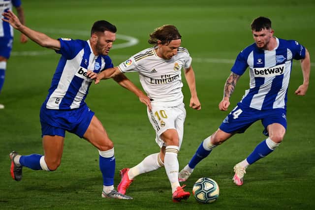 Real Madrid's Luka Modric (C) challenges Alaves' Lucas Perez (L) and Oliver Burke. (Photo by GABRIEL BOUYS / AFP) (Photo by GABRIEL BOUYS/AFP via Getty Images)