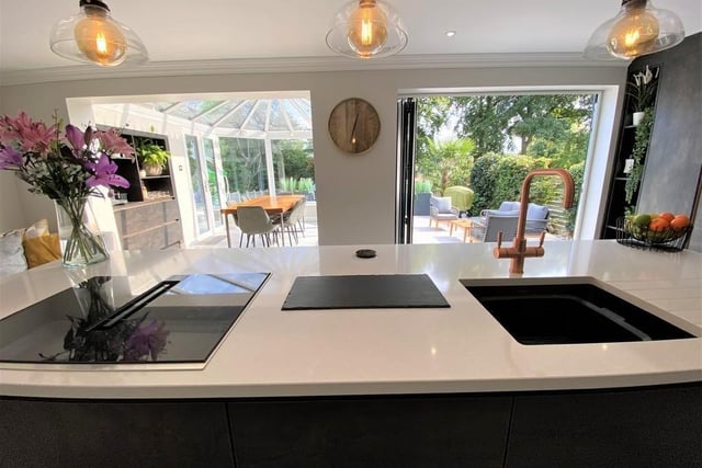 Both the dining room and bi-folding doors get light streaming into the kitchen, making it incredibly bright in the sunshine, or lovely and cosy in the cold. This is the view from the kitchen island out to the dining room and garden.