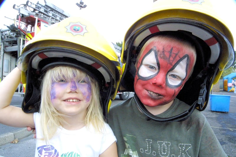 Children with face painted wearing fire firefighter hats