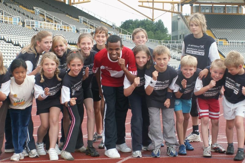 Runner Abdirisak Ahmed with youngsters at Don Valley Stadium’s kids summer holiday camp