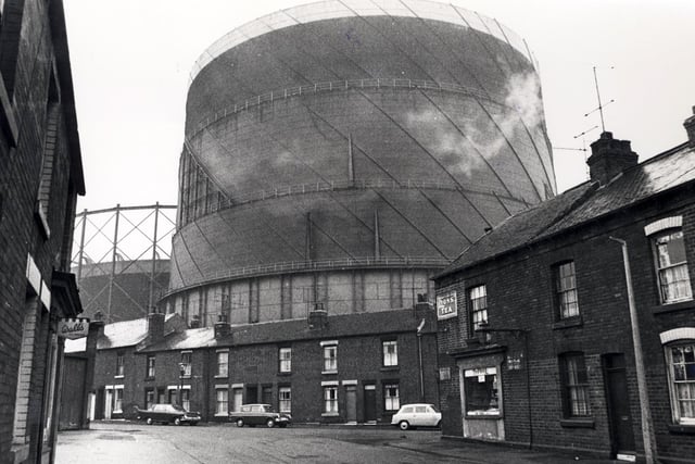 Houses and a corner shop living in the shadow of the Neepsend Gasometers
