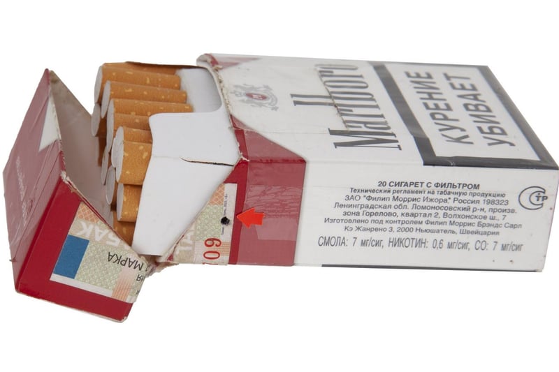 A Russian FSB spy pack of Marlboro brand cigarettes containing a hidden digital camera, with the lens operating through a small hole on the side. Includes remote control unit. 3 1/2 by 2 1/4 by 1 inches. Estimate: $800-$1,200.