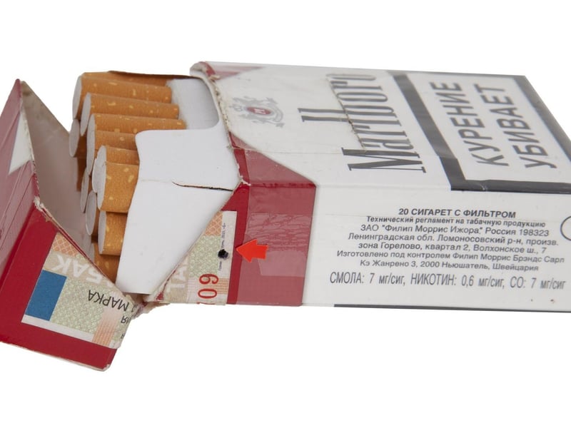 A Russian FSB spy pack of Marlboro brand cigarettes containing a hidden digital camera, with the lens operating through a small hole on the side. Includes remote control unit. 3 1/2 by 2 1/4 by 1 inches. Estimate: $800-$1,200.