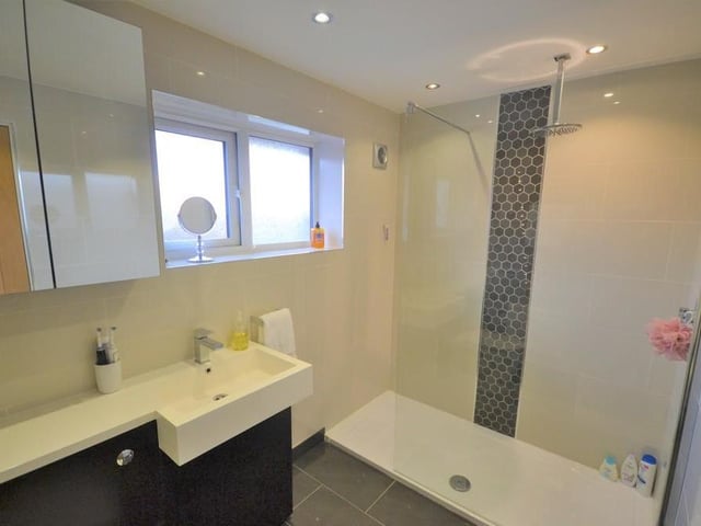 Ensuite - A stylish and immaculately presented ensuite incorporating a large mains fed walk in shower with glass screen, wash basin with chrome mixer tap inset to a vanity unit, matching low level flush w.c. Inset down lighting, extractor fan and complemented with attractive porcelain wall and floor tiles.