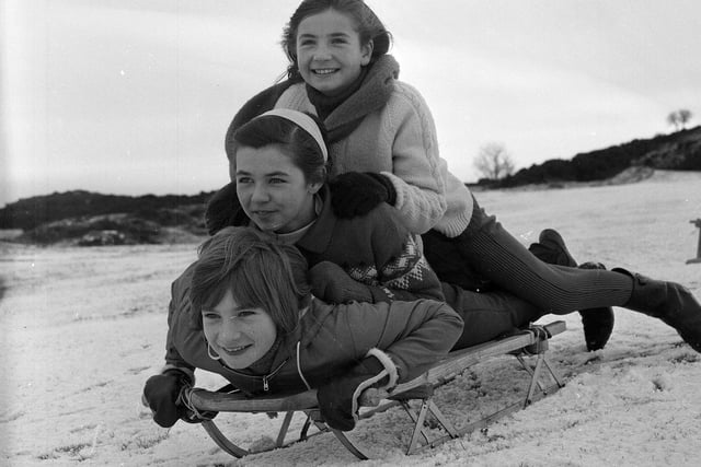 Three girls sledging on the Braid Hills in Edinburgh, November 1964.