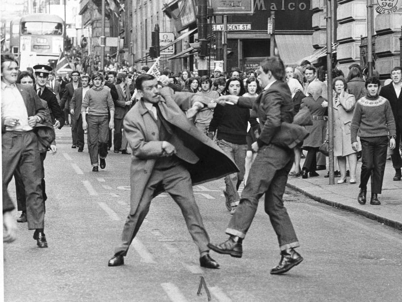 Detective Inspector George Johnstone cigarette in mouth, a special branch detective is slashed by a youth with an open razor in Renfield Street Glasgow  during a pro IRA march in 1971.